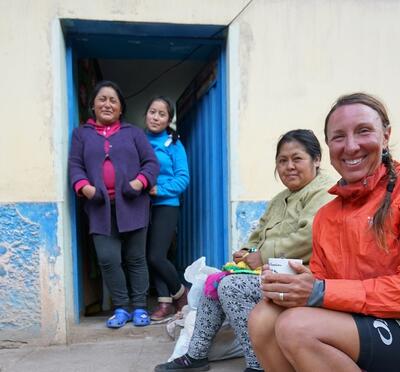 Kristen sitting on log with locals in Peru