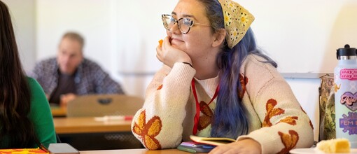 Girl with purple hair and bandana with hand propping chin 