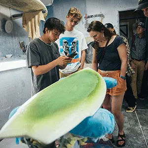 Students examining a surfboard