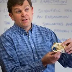 Professor holding small animal skull