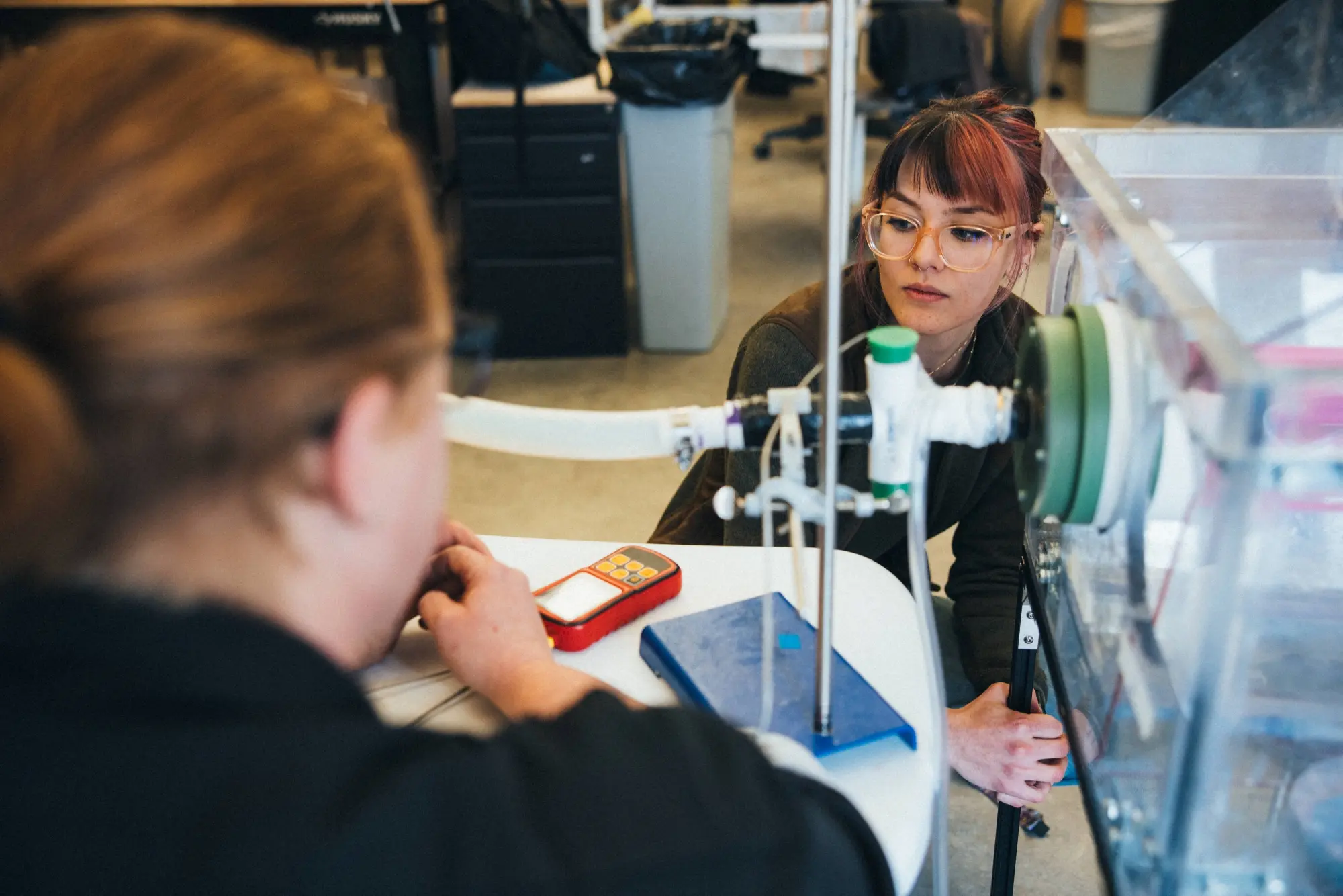 Person using machine during lab while looking at a red meter