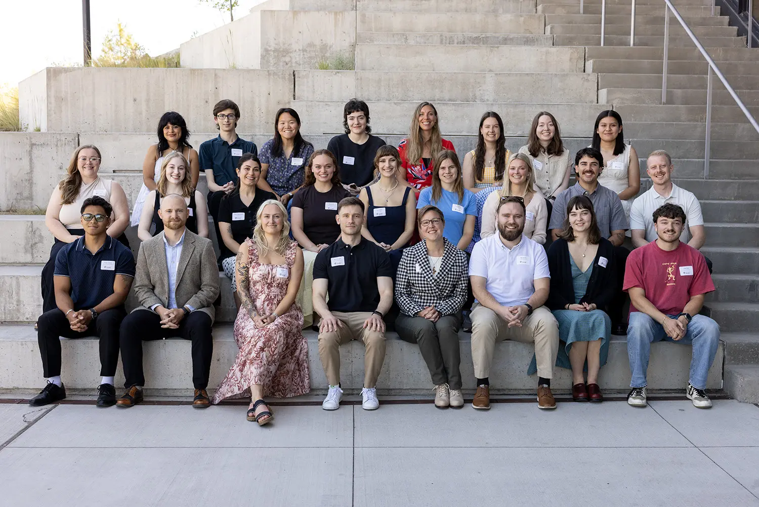 Class of 2026 distinguished students sit for a group photo on cement steps.