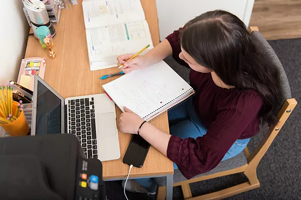 student at residence hall desk