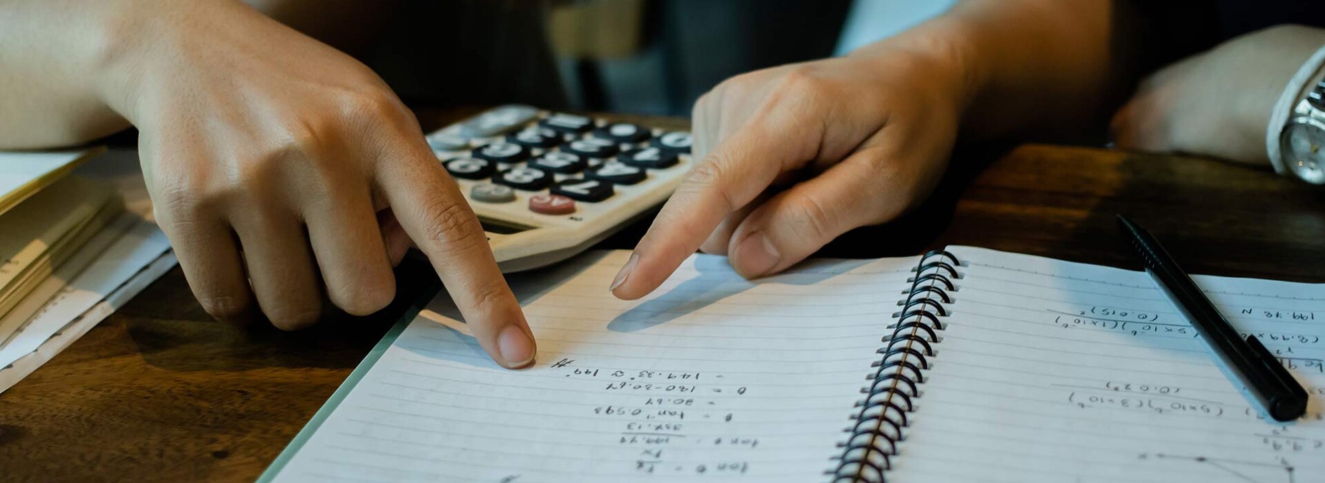 Hands pointing at paper with numbers