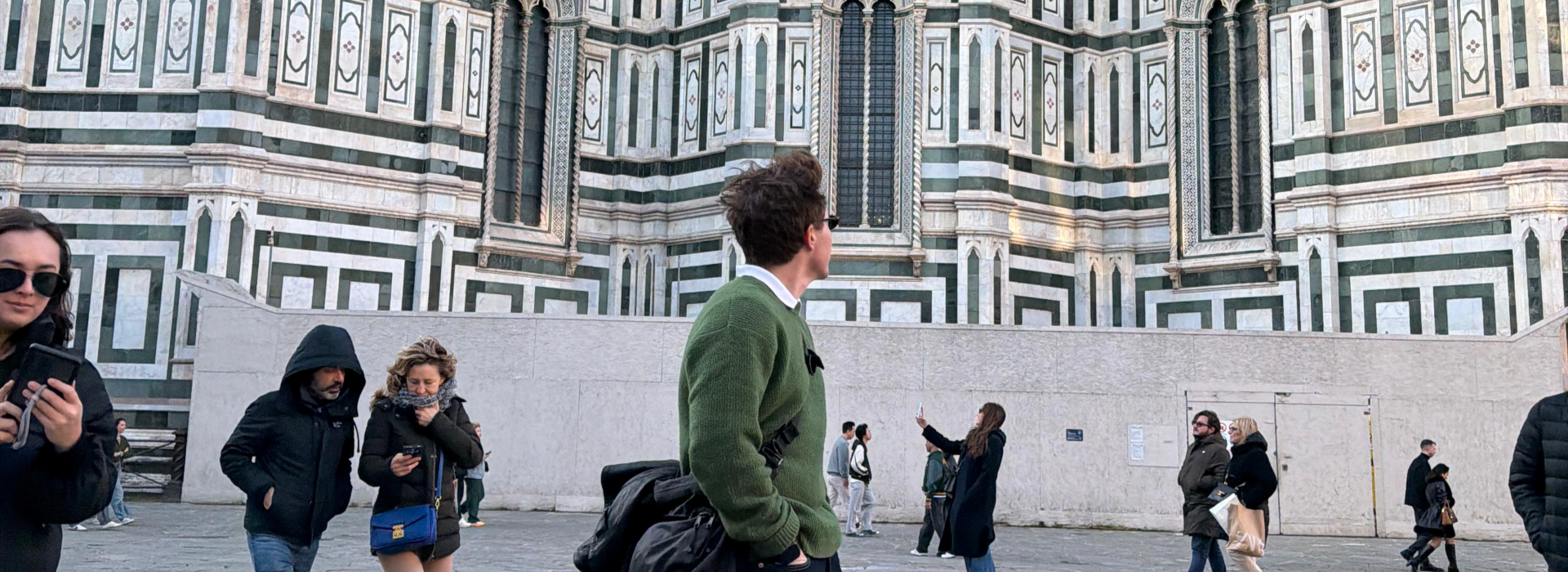 Blair standing in a crowd of people staring at buildings