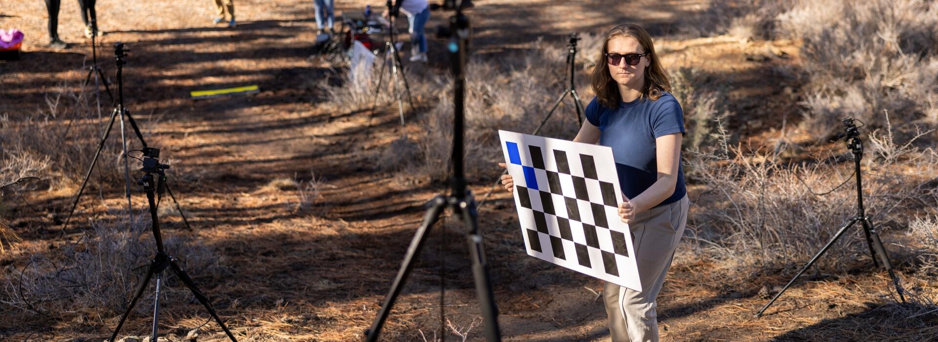 People on track holding a checkerboard