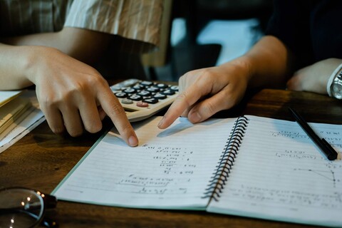 Hands pointing at paper with numbers