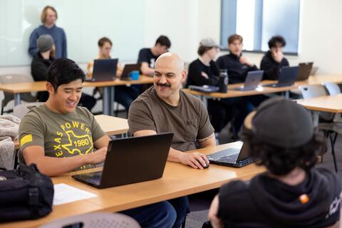 Students sitting at desks talking to each other