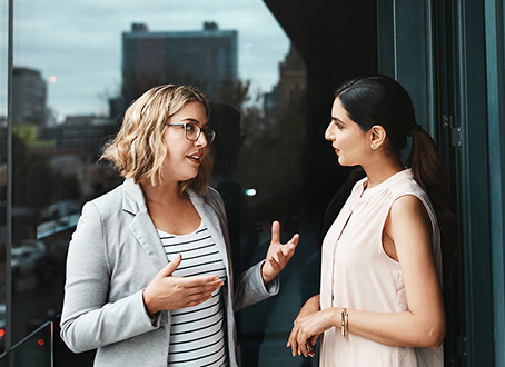 Two women talking on an outside deck