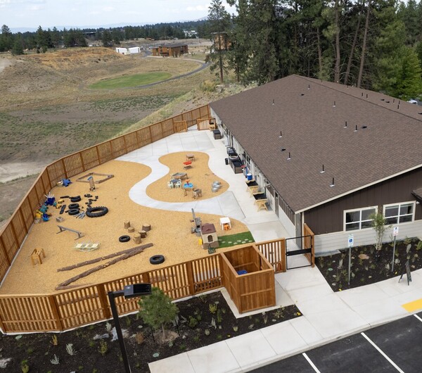 Aerial view of childcare center at OSU-Cascades with building, parking lot and outside play area.