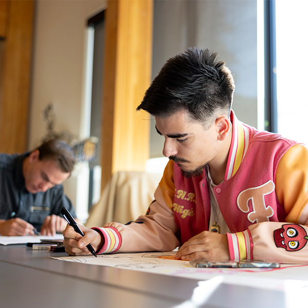 male student at desk, writing